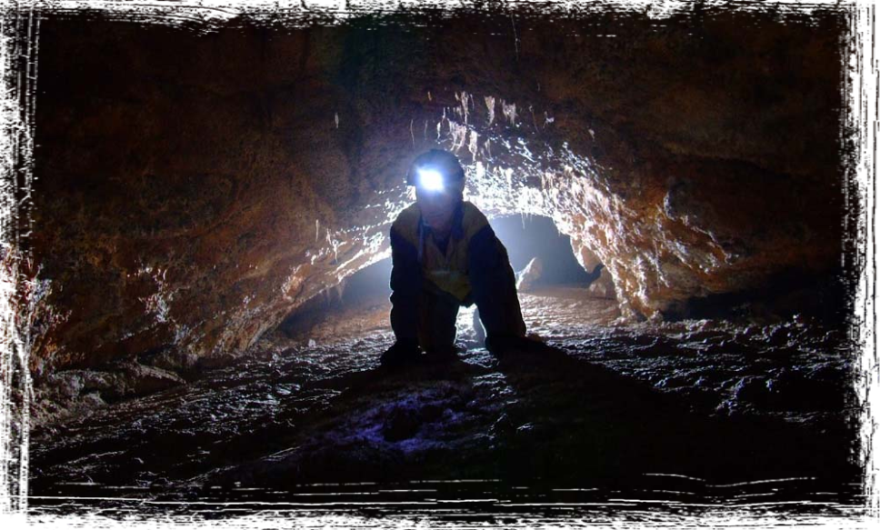 A caver inside a volcanic cave at Mt Eccles, Victoria